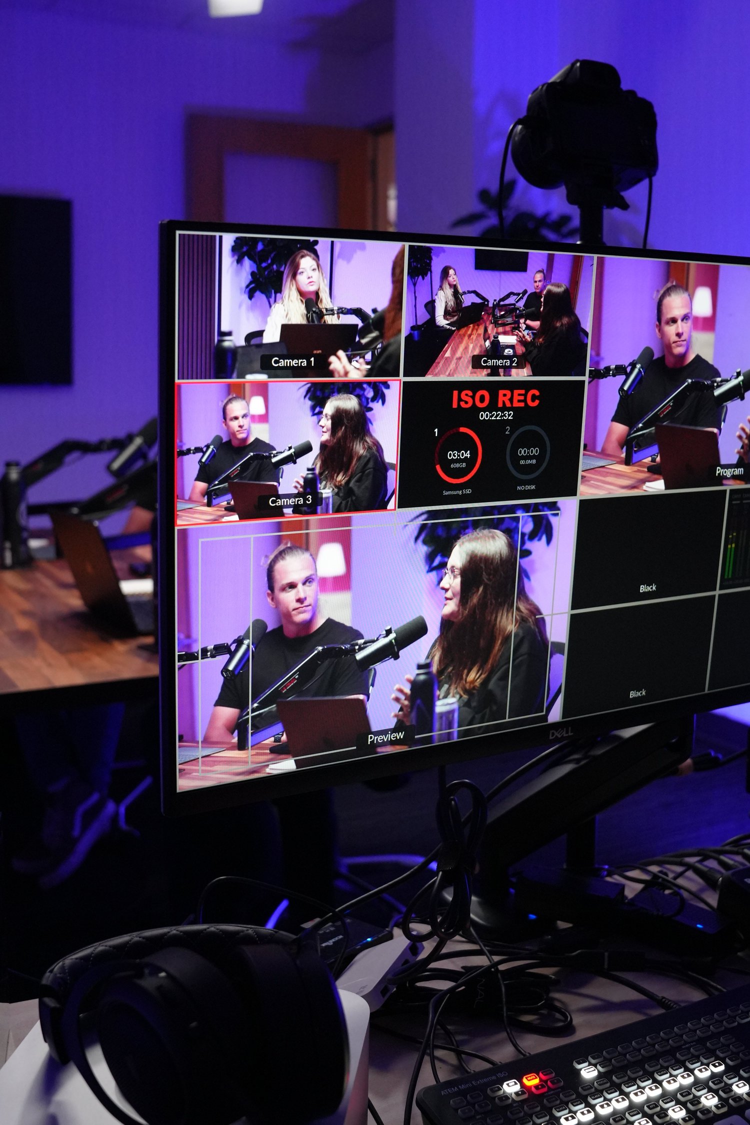 Video production control monitor showing four camera feeds of a corporate recording session
