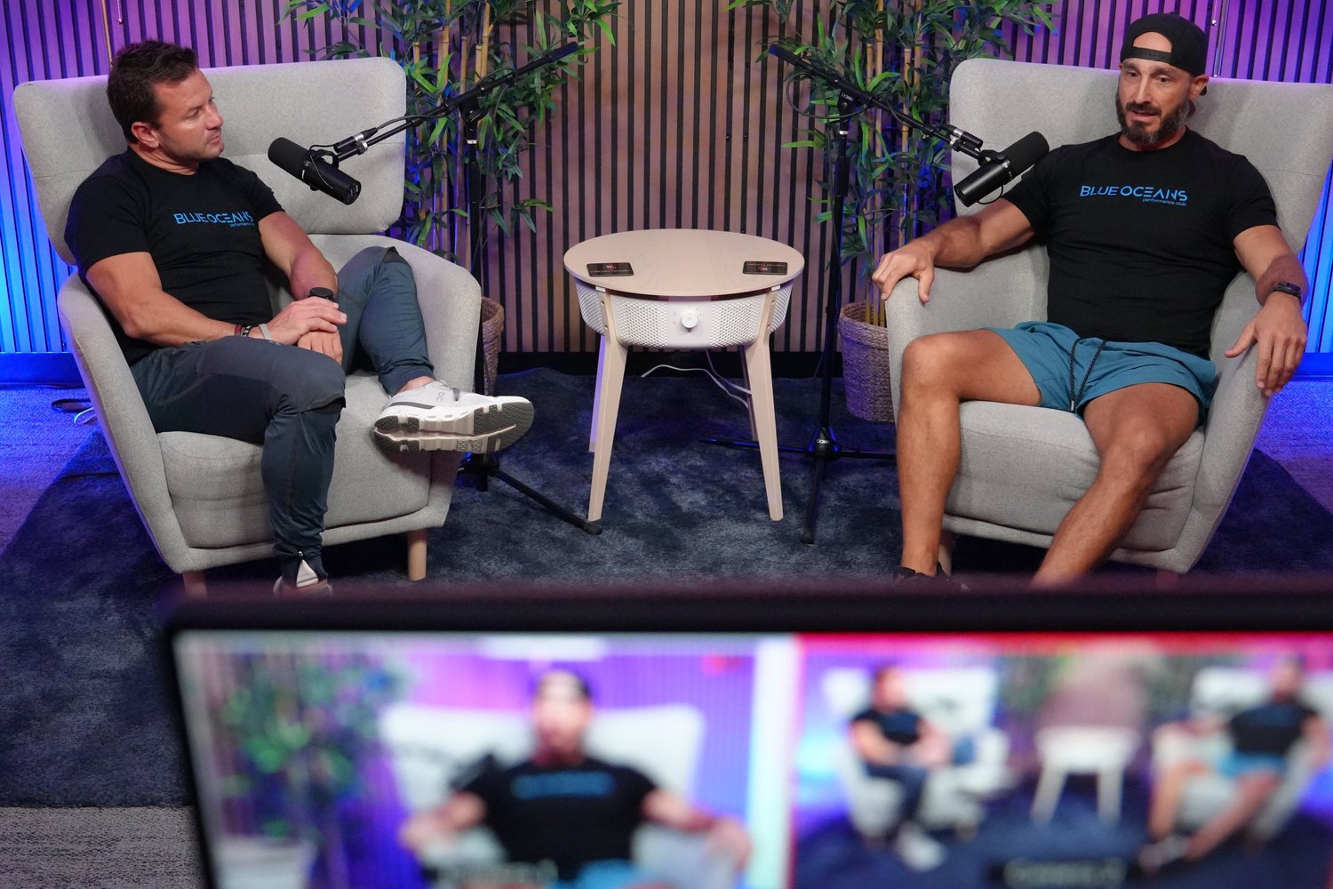 Two hosts recording in the armchairs on Set A